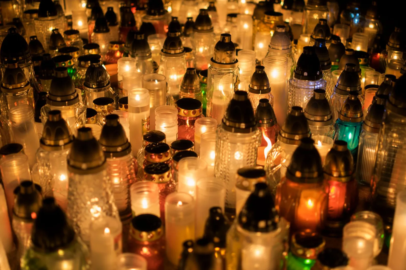 A warm glow of candles illuminates the cemetery for All Saints' Day.