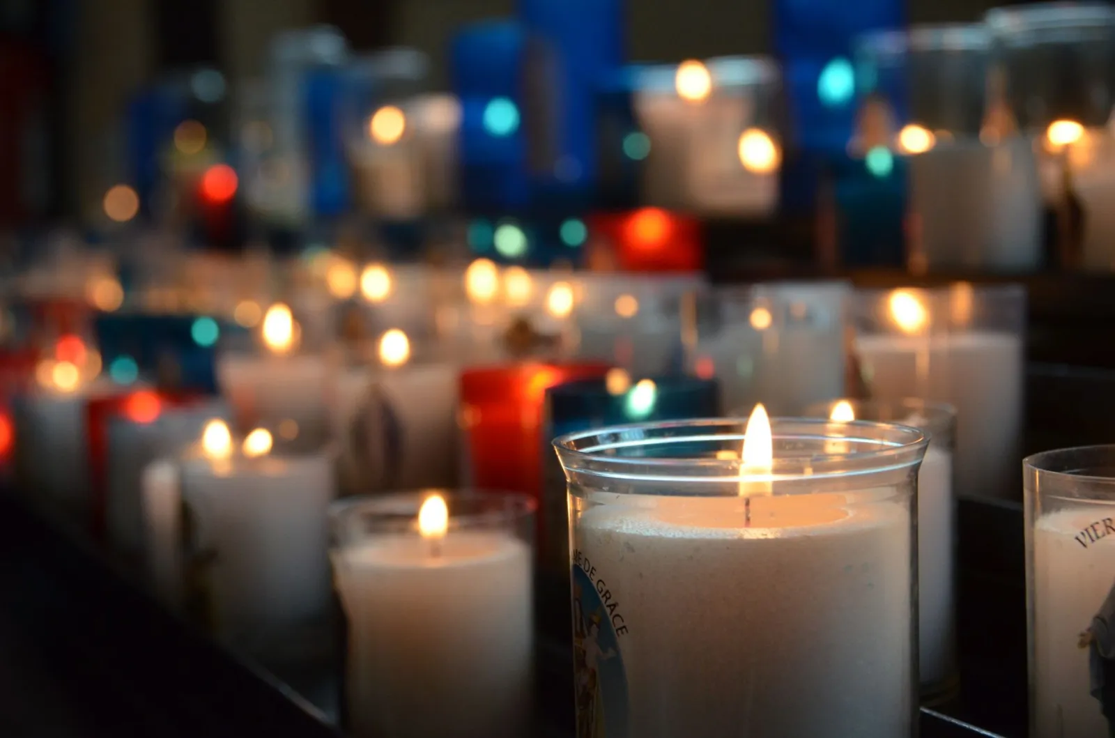 A collection of lit candles in a church, creating a serene and warm atmosphere.